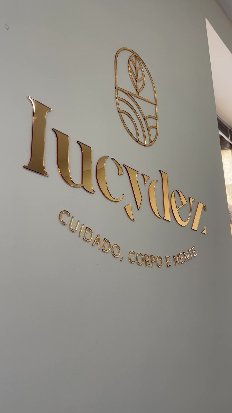 O logótipo dourado da Lucydez na parede do escritório
